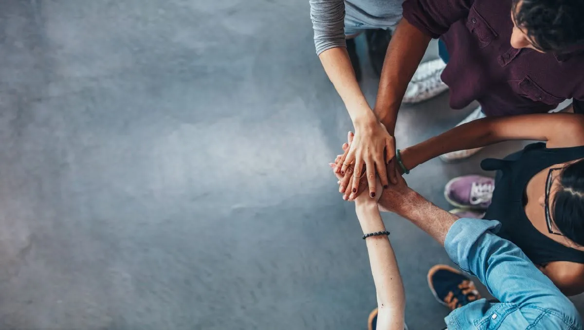 Colleagues joining hands in a sign of collaboration