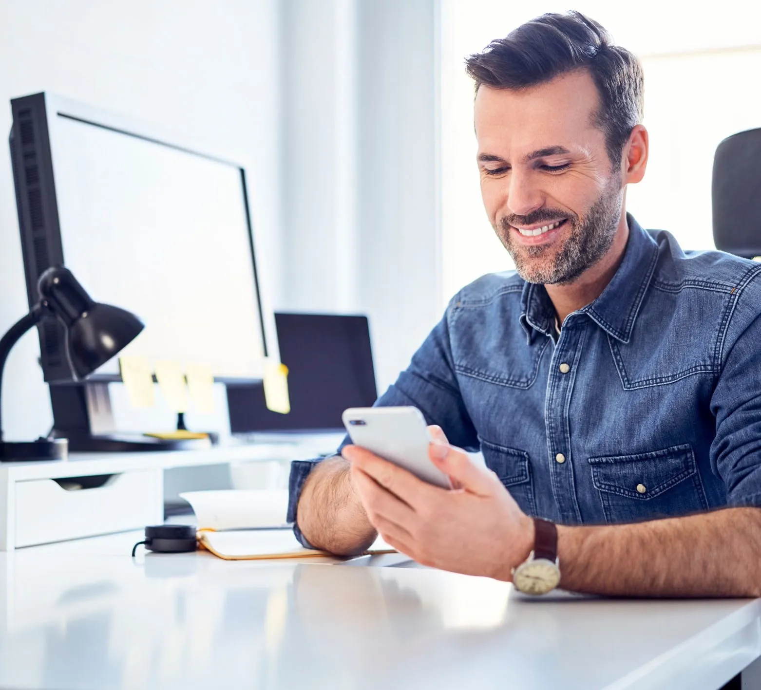Professional using a smartphone at a desk