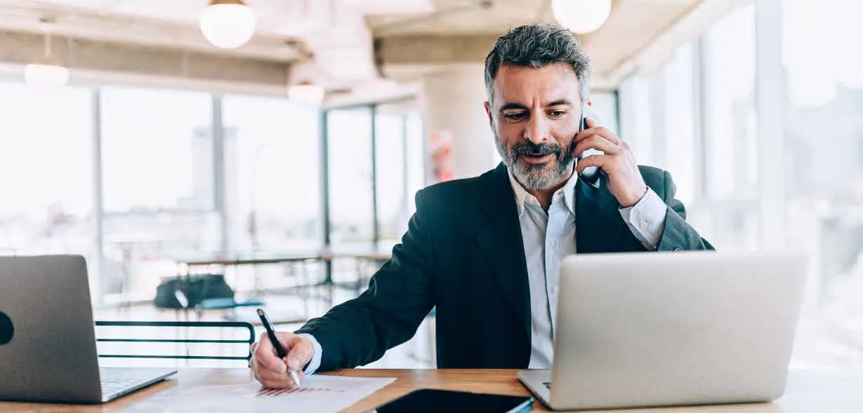 Professional on the phone while signing documents